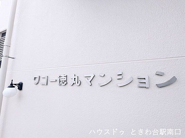 ホワイトの外壁に映えるマンション銘板。落ち着いた住環境を象徴するシンプルで洗練されたデザインが、住まう方を優しく出迎えます。