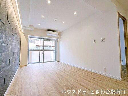 天井のダウンライトと柔らかな間接照明が落ち着いた雰囲気を醸し出すリビングです。新規エアコン設置済みで、年中快適にお過ごしいただけます。