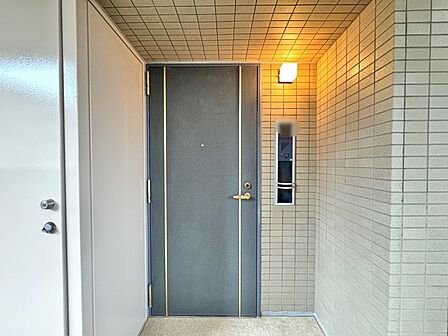 落ち着いた色合いのタイルが重厚感を醸し出し、帰宅のたびに安らぎを感じさせてくれる穏やかな玄関まわりです。