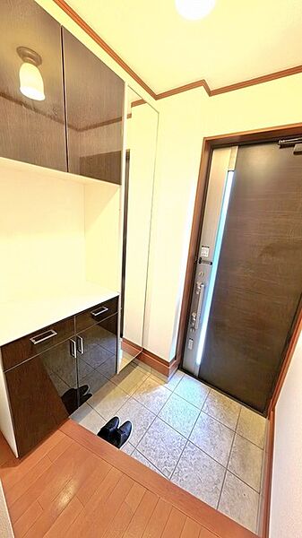 深い色調の建具が洗練された印象を与え、帰宅する人を穏やかに迎えてくれる端正な空間です。