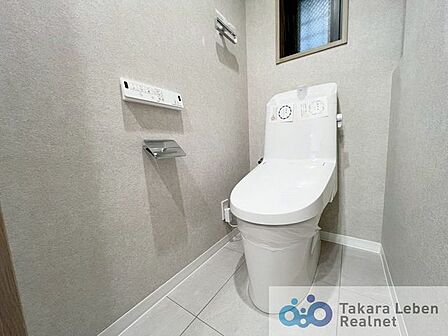 小窓があり採光・換気良好の温水洗浄機能付きトイレ。リモコンは操作がしやすい壁掛けタイプです。