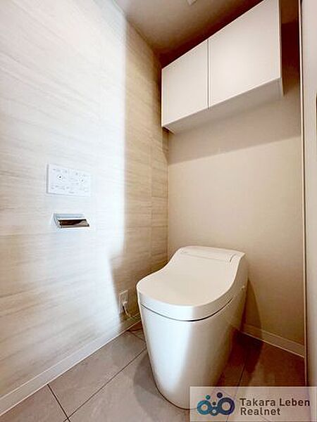 ウォシュレット機能付きのトイレは壁掛けリモコンの上位グレードを採用。便座がスッキリした印象となり、限られた空間を広く見せる効果があります。