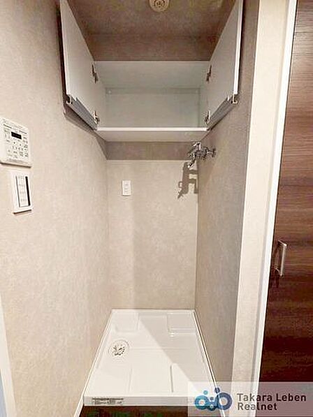 洗面スペースには防水パン付きの洗濯機置場があります。上部の棚は洗剤やタオルなどの収納に便利。