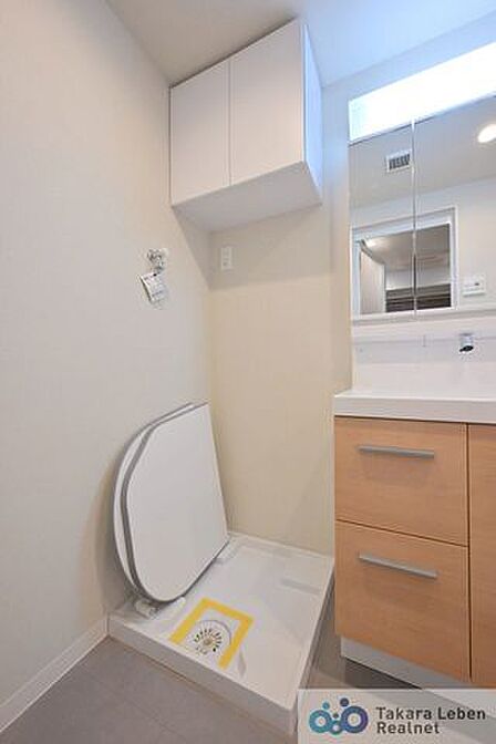 洗面台の横には、防水パン付きの洗濯機置き場があり、家事動線に配慮した配置になっています。