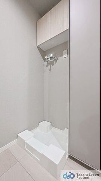 洗面スペースには防水パン付きの洗濯機置場があります。上部の棚は洗剤やタオルなどの収納に便利。