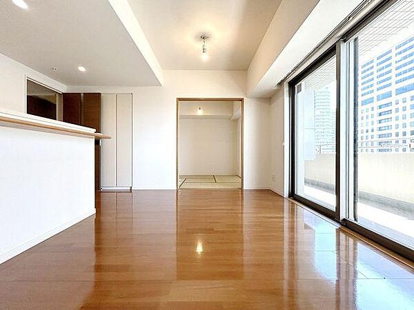 ナチュラルな木目調の床から木のぬくもりを感じられる広々としたリビングルーム。
