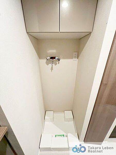洗面スペースには防水パン付きの洗濯機置場があります。上部の棚は洗剤やタオルなどの収納に便利。