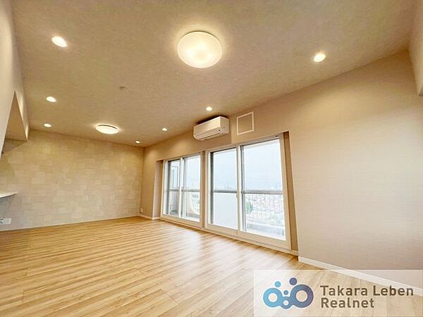 大きな窓からたっぷりと陽光が差し込む明るいリビング。家族が自然と集まり、くつろぎの時間を共有できる心地よい空間です。