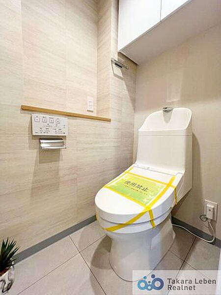 ウォシュレット機能付きのトイレは壁掛けリモコンの上位グレードを採用。便座がスッキリした印象となり、限られた空間を広く見せる効果があります。