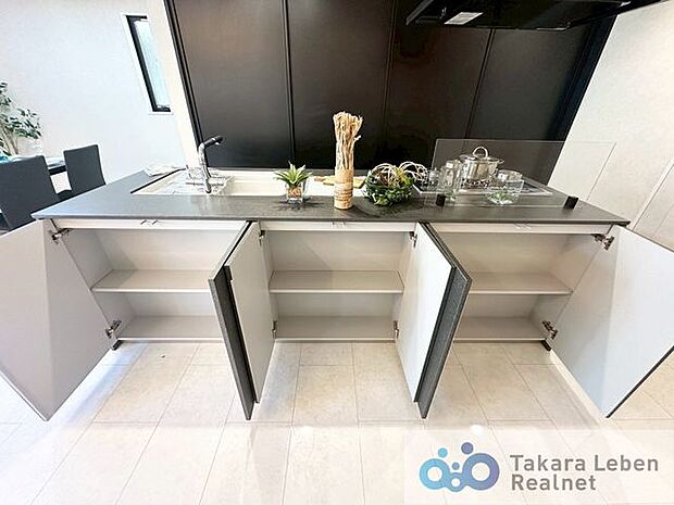 システムキッチンのリビング側は収納戸棚となっております。生活雑貨の収納に便利ですね。