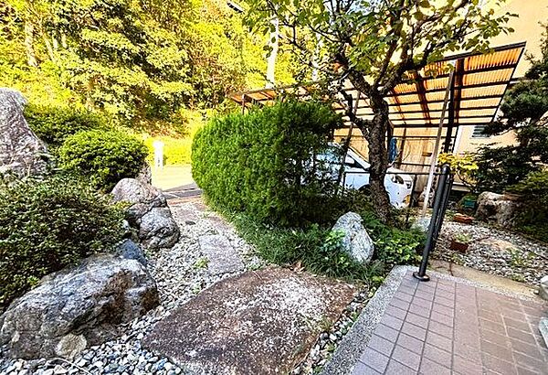 道路から玄関まで飛び石が敷かれています。景石や庭石がデザインされた趣きのあるお庭です。