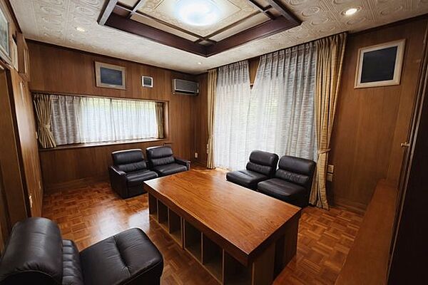 重厚感のある木目調の内装が印象的な応接室。大きな窓からやわらかな光が差し込む、上質感のある応接スペースです。※AIで一部家具消し処理を行っております。