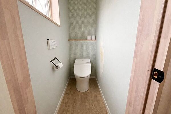 ナチュラルな色味で仕上げた、やさしい雰囲気。小窓から光が入り、落ち着きのあるトイレ空間♪※AI加工を施しています。