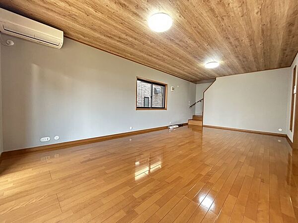 ナチュラルな木目調の床から木のぬくもりを感じられる広々としたリビングルーム