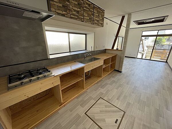 - キッチンの素材感が上品木のカウンターと石調の吊り戸棚、そしてグレーの壁面がバランスよく調和していて、落ち着いた大人の雰囲気をつくっています。
