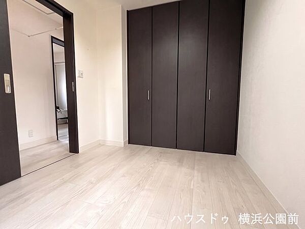 4.7帖の洋室には、壁一面に広がる大容量のクローゼットを完備。お部屋の中に余計な家具を置かず、空間を広々と有効活用♪白のフローリングにダークブラウンの扉が映える、メリハリの効いたお洒落な空間です。