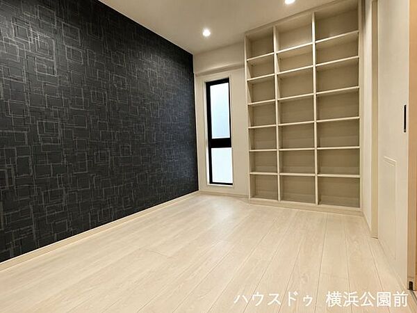 1階6.4帖の洋室。アクセントクロスが上質なリラックスタイムを演出し、一日の疲れを癒してくれます。大容量の壁面本棚が特徴で、お気に入りのコレクションに囲まれた、こだわりのプライベートルームが作れます。