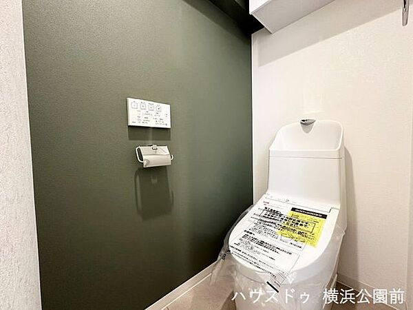 温水洗浄便座を完備。壁掛け式リモコンや上部の収納棚など、使いやすさと実用性を重視した造りです。シンプルで落ち着いた雰囲気の、すっきりと清潔感のある空間です。