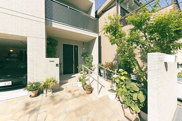 玄関前にはステップだけでなくスロープもございます。余裕のあるスペースには植樹された緑や花々が季節にあわせた色合いで来客をお迎えします。広々としたスペースには自転車等を置くことも可能です。