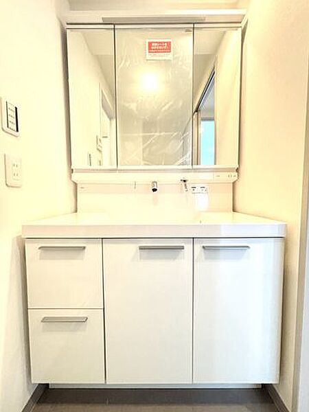 洗面台は三面鏡タイプ。いろいろな方向から確認ができるので大変便利です。鏡の後ろは収納スペースとなっており、ヘアケア用品や洗面用品などを収納することが出来るので洗面所まわりがスッキリします。