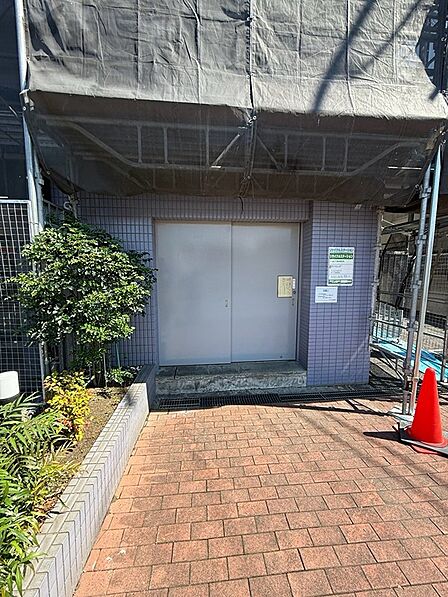 建物入口前のアプローチは、タイル舗装で管理されています。植栽が周囲に彩りを添え、建物の印象を引き立てます。