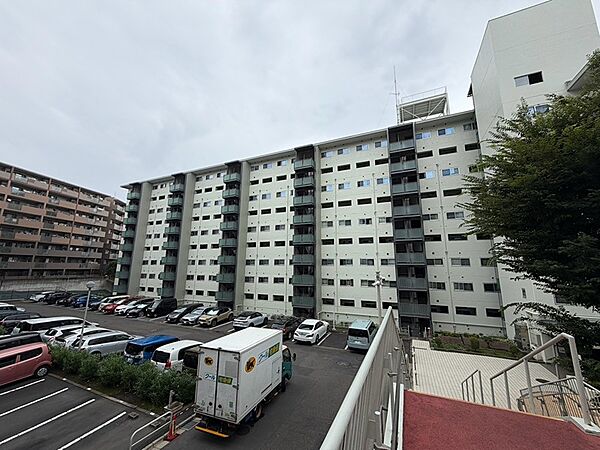 落ち着いた色調の外観が街並みに調和するマンションです。ゆとりのある駐車場が日々の暮らしをサポートします。