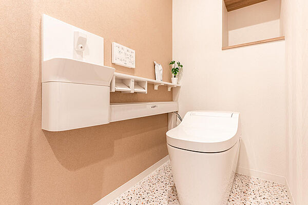 収納棚付きで、ペーパーやストックもすっきり収まるトイレ空間。