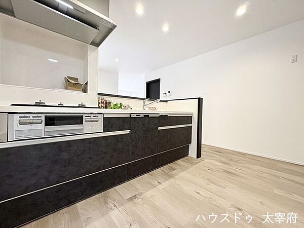 優しい木目調のフローリングとシックなキッチンカラーの組み合わせが美しく、照明との相性も◎毎日の家事時間も気分が上がる、デザイン性の高いキッチンです。