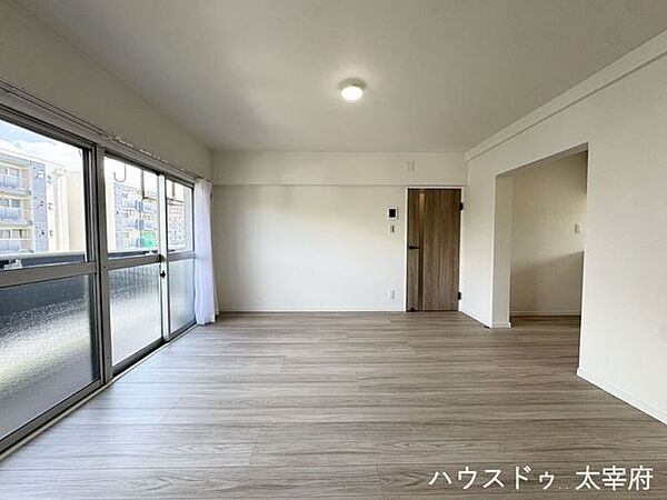 大きな窓からたっぷりの光が差し込む明るい15帖のLDK。白のクロスと木目調フローリングで開放感がありながらも温かみのある室内です。