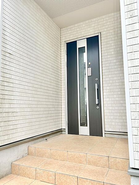 奥行きのある玄関アプローチで、雨の日も出入りしやすい設計。明るく清潔感のある玄関まわりです。