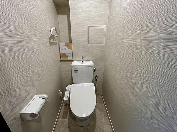 清潔感のある温水洗浄便座付きトイレ。落ち着いた色味で統一されたトイレ空間です。
