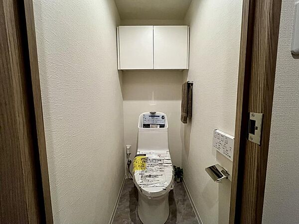 温水洗浄便座付きトイレ。上部収納も備えた使い勝手の良い空間です。