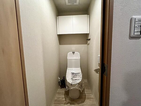 温水洗浄便座付きトイレ。上部収納も備え、すっきりとした空間を保てます。