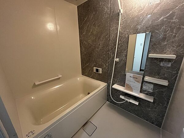 大きな鏡を備えた、すっきりとした印象のバスルームです。