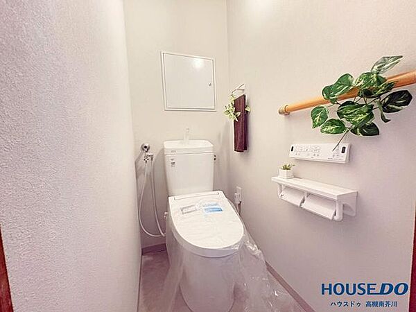 清潔感あふれるホワイト調で統一された温水洗浄便座付きトイレです。手すりやペーパーホルダーも備わっております。