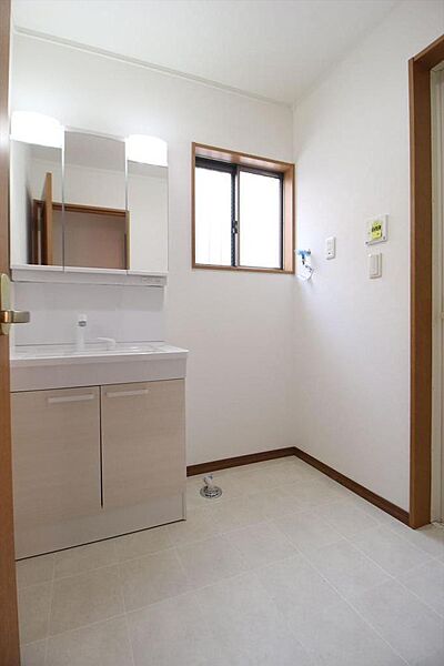 明るく整った洗面室。シャワー水栓＆3面鏡スタイルで収納部もあり使い勝手の良い仕様です。