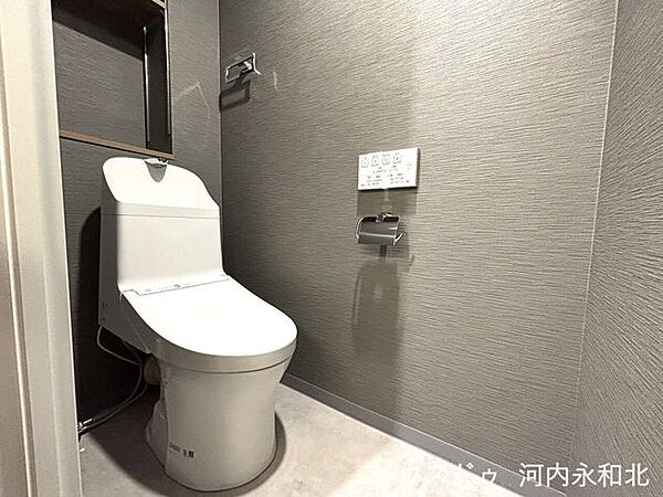 スタイリッシュな手洗い一体型トイレ。奥には小物をすっきり飾れる便利な棚付きです。