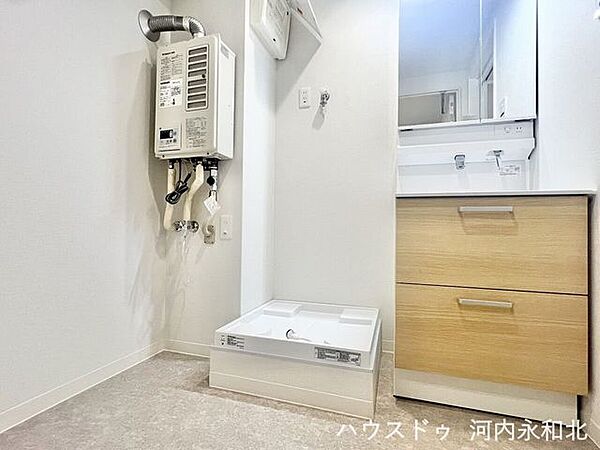 洗濯機置場と洗面台が隣接し、家事効率の良い配置。白を基調とした明るい洗面室です。