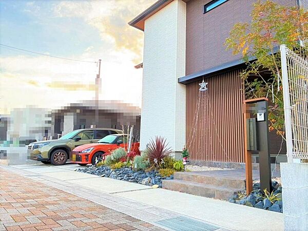玄関アプローチ傍の外構、玄関ドアは木風ルーバーにより道路からの視線をカット