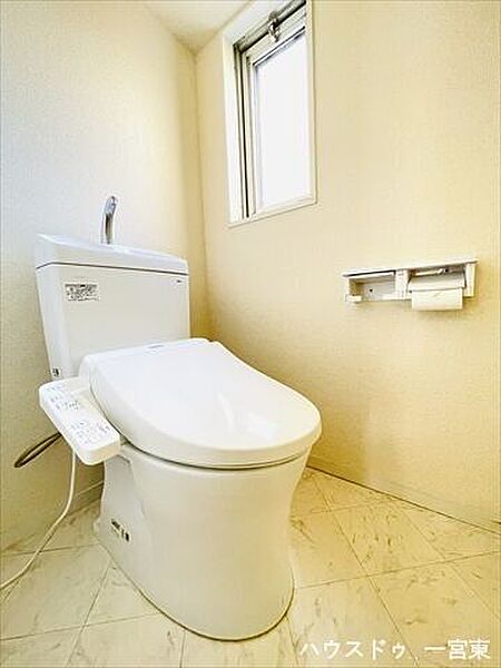 白を基調としたシンプルな壁紙のタンク付きトイレです。ペーパーホルダーが2つあるのも嬉しいポイントですね♪
