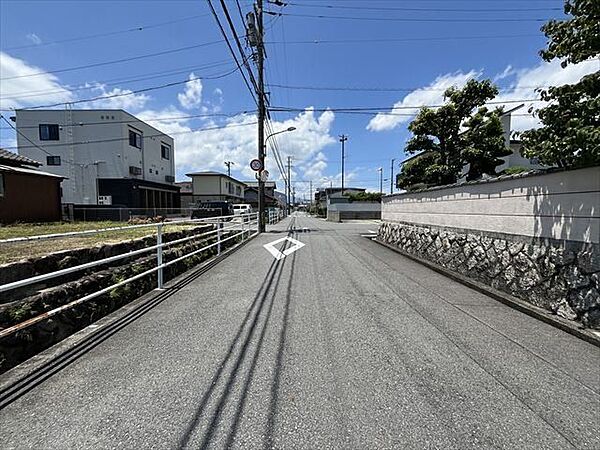 水路を挟んだ道路です。車がすれ違うのに安心な道幅です。道幅が広すぎると交通量が増えてしまうのも心配ですので、これぐらいが理想的な道幅なのかもしれませんね。（2025年6月17日撮影）