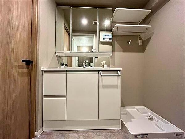 洗濯機の上に棚を完備。ストック品やタオルなどの収納に良さそうです。洗面台は朝の支度に便利な三面鏡付き♪