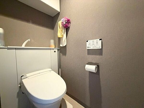 温水洗浄便座を備えたトイレ。背面には収納スペースも設けられており、トイレットペーパーや清掃用品を目立たせず保管できます。