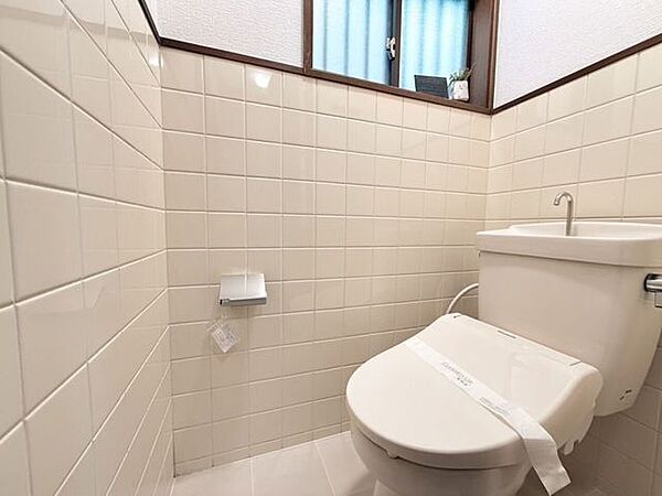 タイル張りで清潔感があり、窓付き・ウォシュレット完備のトイレです。