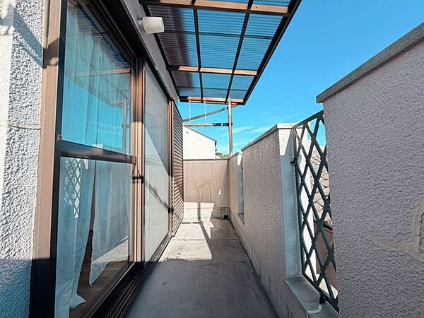 屋根付きで物干し金具がある、開放的なバルコニーです。
