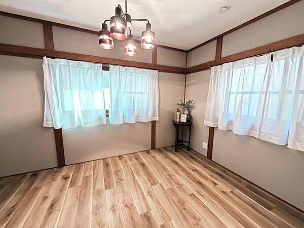 2階モダンな照明が映え、二面採光で明るい木目調の洋室です。