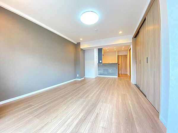 自然な木目の床とアクセントクロスが調和したリビング。明るい空間で、心地よい毎日を過ごしませんか。