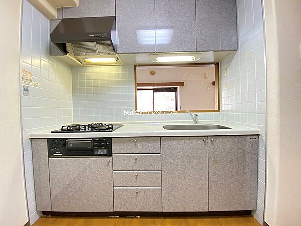 調理が捗る3口ガスコンロと、収納力のある引き出しが魅力のキッチン。小窓からリビングの様子も伺えます。