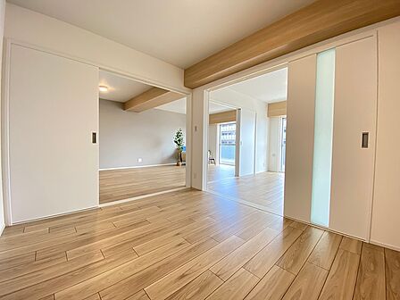 木目の美しいフローリングが印象的な室内。引き戸を開ければ、開放感あふれる空間が広がります。