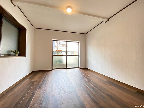 大きな掃き出し窓から優しい光が差し込む洋室です。